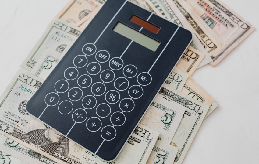 An electronic calculator lying on the dollar notes