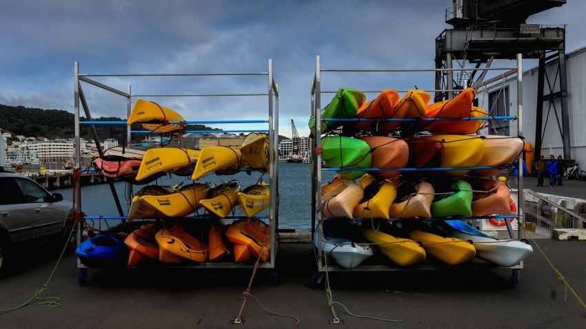 Multi-color kayaks stored on a rack in a harbor