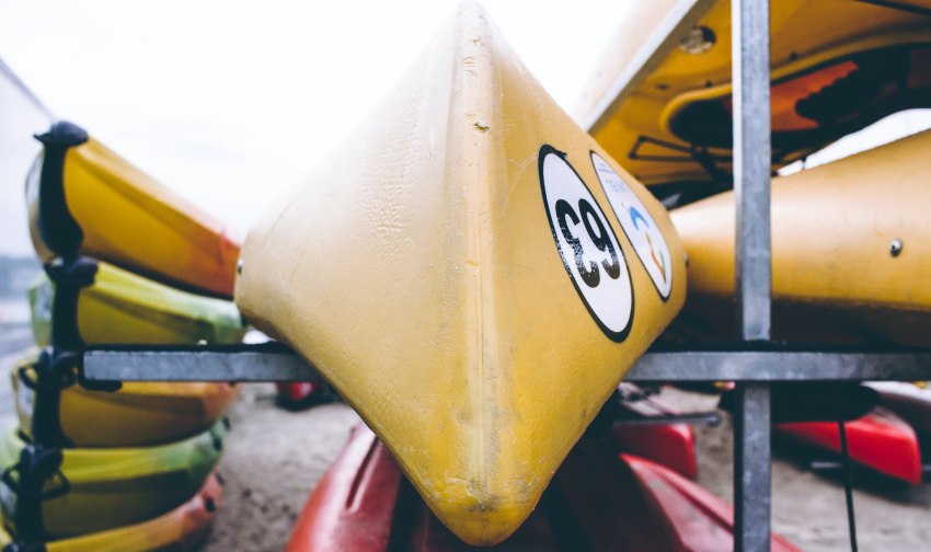 Yellow and green kayaks stored on a rack
