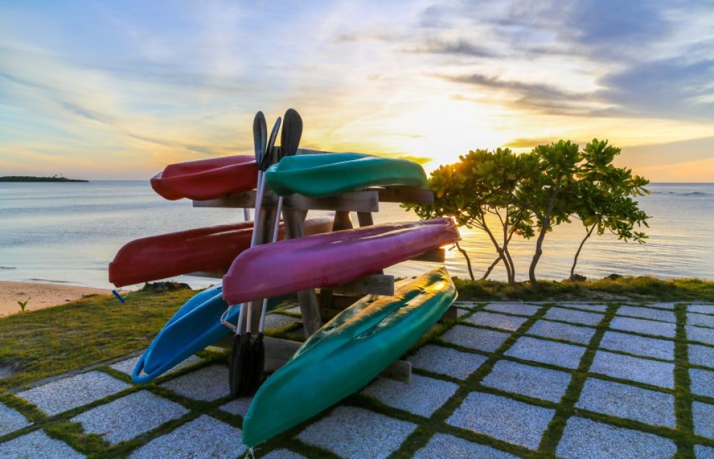 Multi-color kayaks stored on a rack near the water