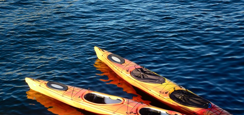 Two orange kayaks floating on the water