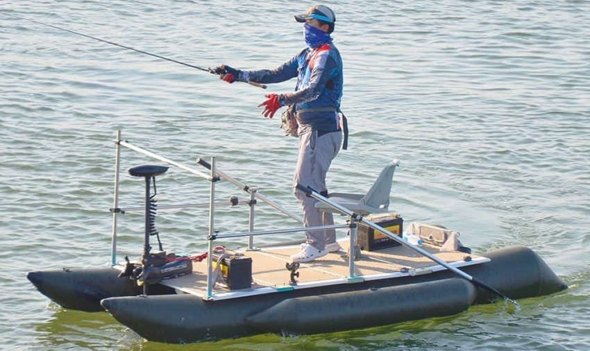An angler casts the line from his inflatable boat, powered by a trolling motor