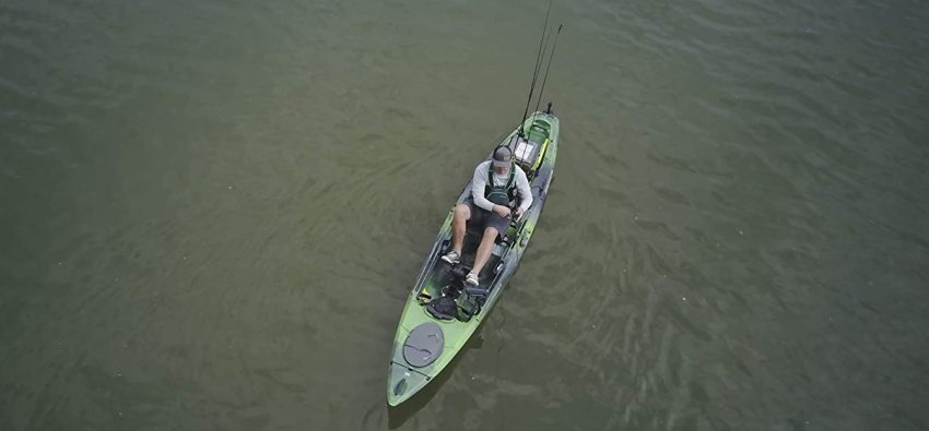An angler sits on a kayak and casts his bait