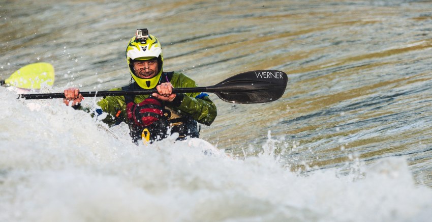 A man with a black paddle in the whitewater