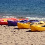 Plastiс kayaks of different colors lying on the beach