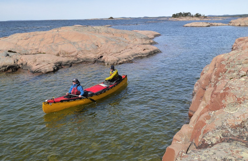 Two people paddle a tandem canoe in costal waters