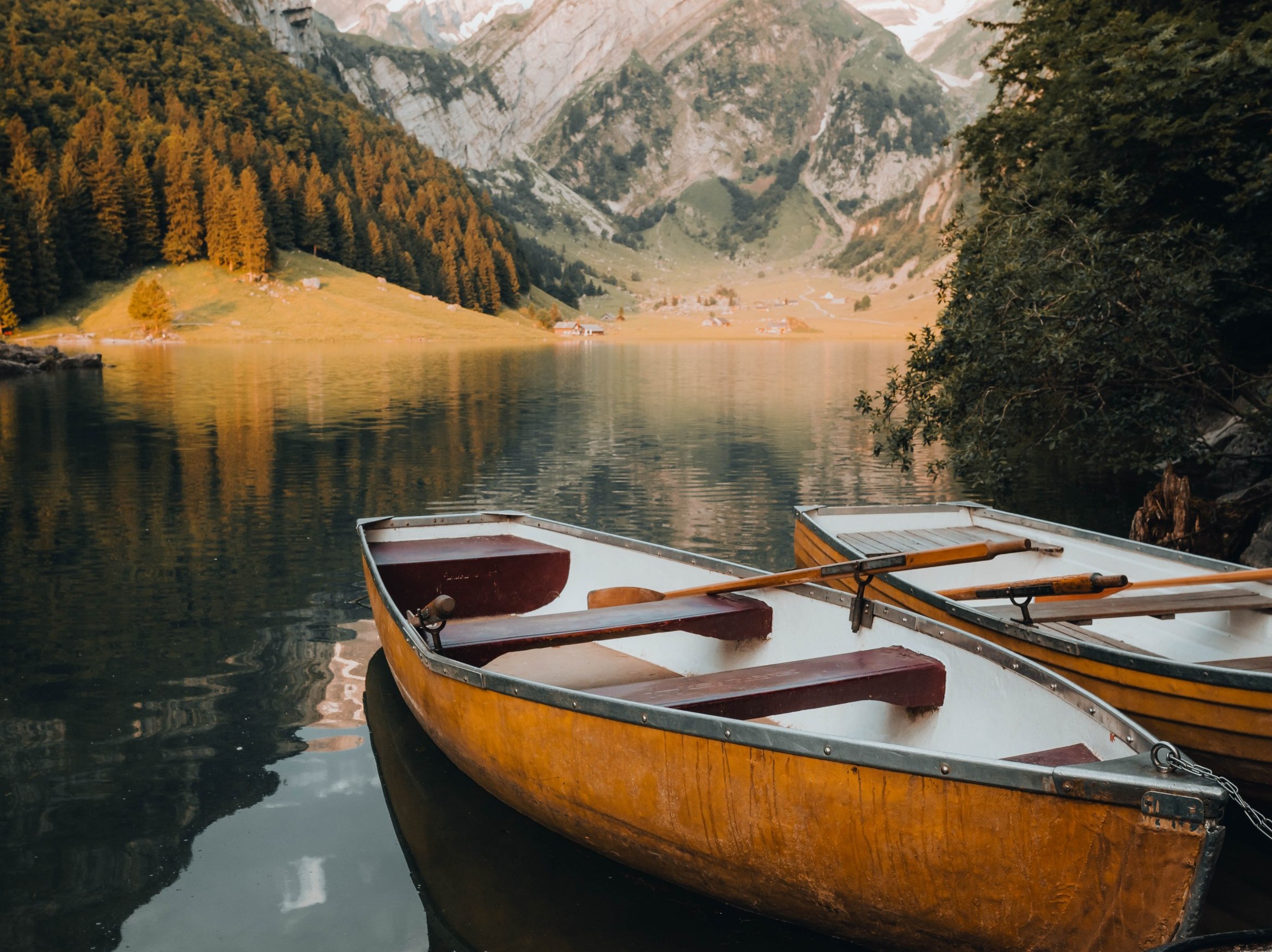 Two yellow canoes are parked on a beautiful mountain lake