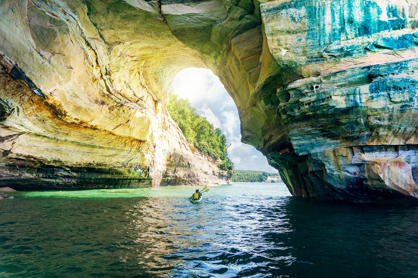 Two men ia an kayak with paddlers sail in a lake cave