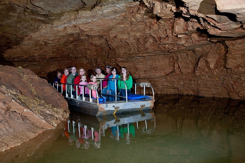 A group of people takes a boat tour in the Indiana Caverns