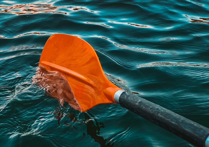 An orange paddle in the water