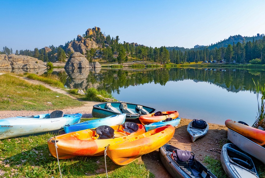 Several kayaks of different colors on the shore of Sylvan Lake