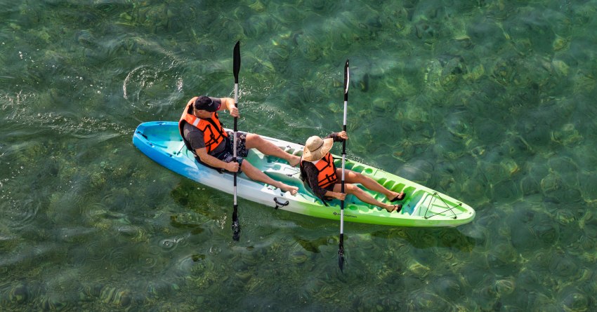 A couple paddles their tandem plastic kayak