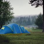 A blue tent pitched in a forest