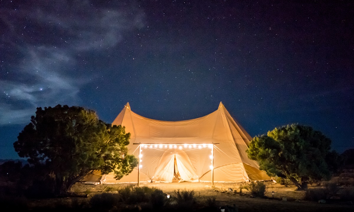 A canvas tent with lights outside