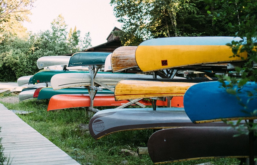 Canoes of different colors are stored on racks 