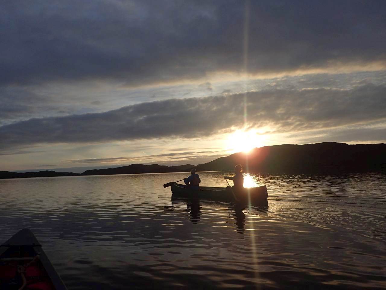 A couple paddles their canoe at sunset