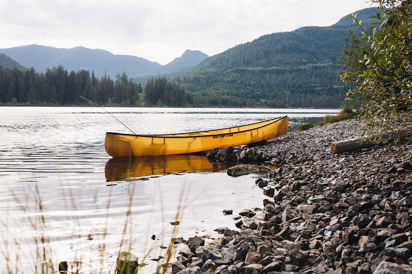 Yellow Nova Craft Prospector 16 canoe on a lake shore