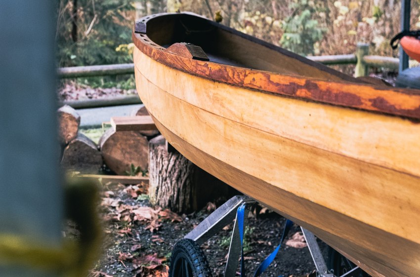 A wooden canoe rests on a rack