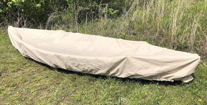 A boat, wrapped in a canvas cover, is lying on the grass