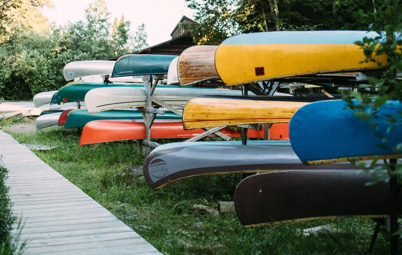 Multiple canoes are stored on racks