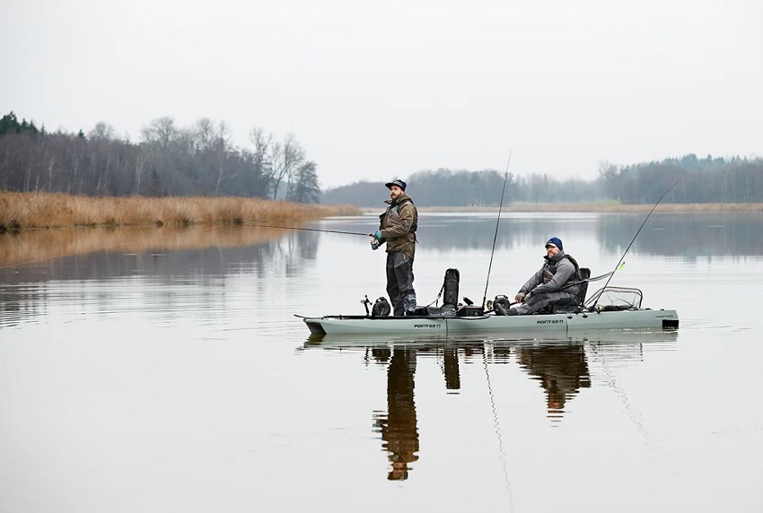 Two man fish from a gray modular kayak on a lake