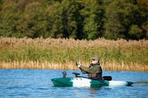 A man fishes from a modular kayak on a lake