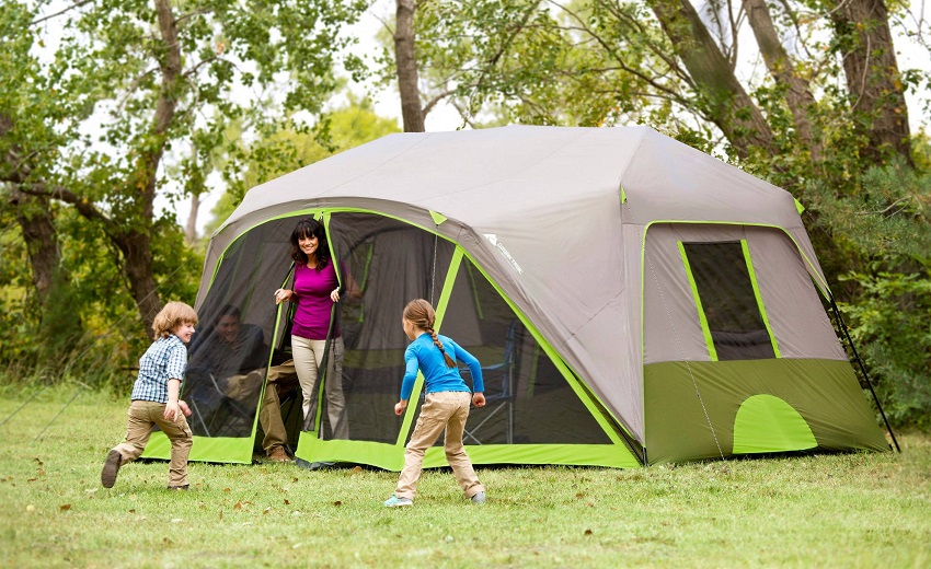 A woman looks at her children playing outside the Ozark Trail 9-Person Instant Cabin Tent
