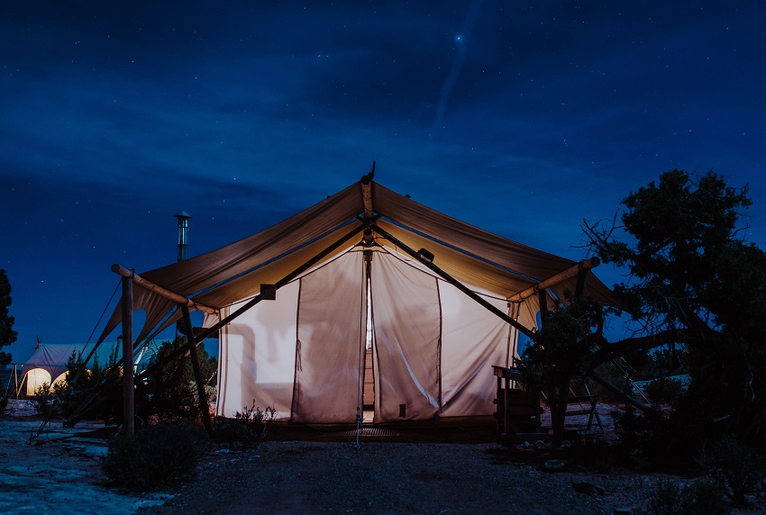 A tent with a stove jack at night