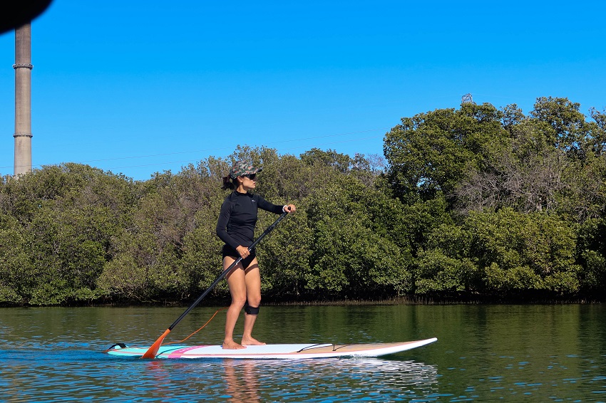 A woman paddles a touring paddle board