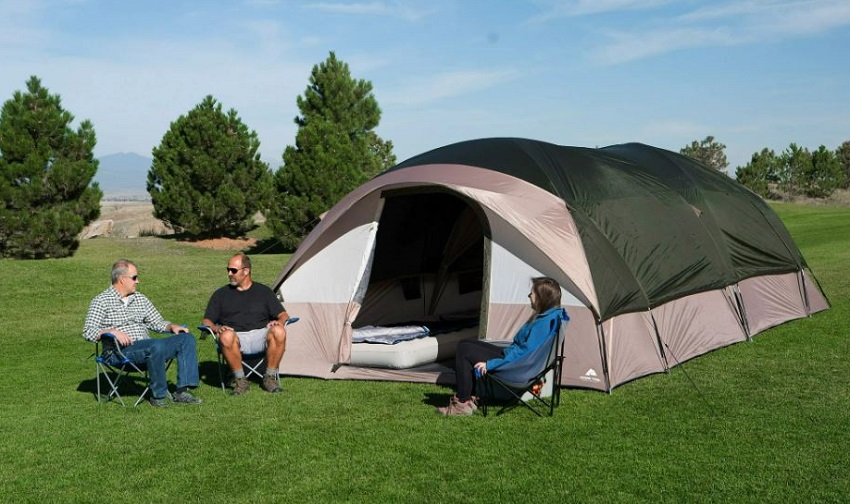 Two men and a woman sit in camping chairs near the Ozark Trail Hazel Creek 20-Person Tunnel Tent