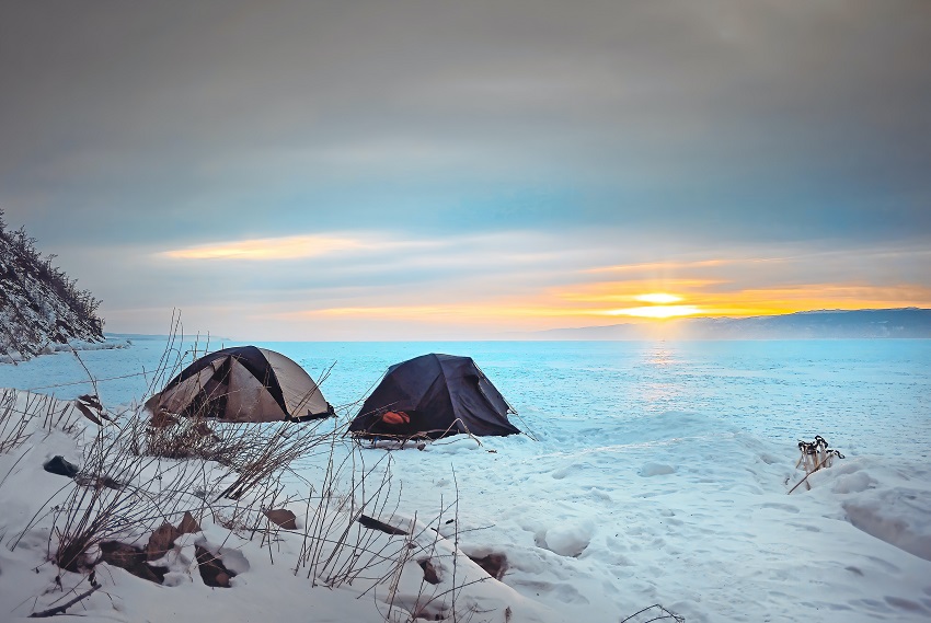 Two camping tents are pitched on the snow