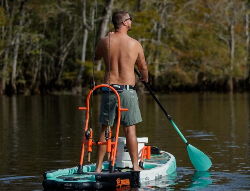 A man paddles a stand up fishing paddle board