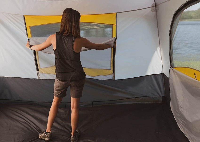A woman opens a mesh window inside the Browning Camping Big Horn Tent