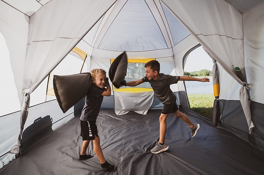Two boys play with pillows inside the Browning Camping Big Horn Tent
