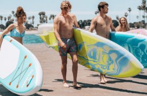 A company of people carries inflatable SUPs