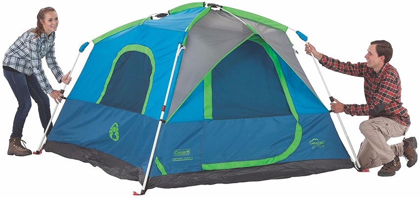 A woman and a man are setting up a tent