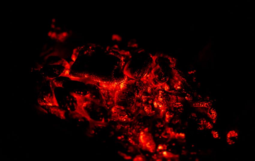 Campfire coals are glowing in the dark