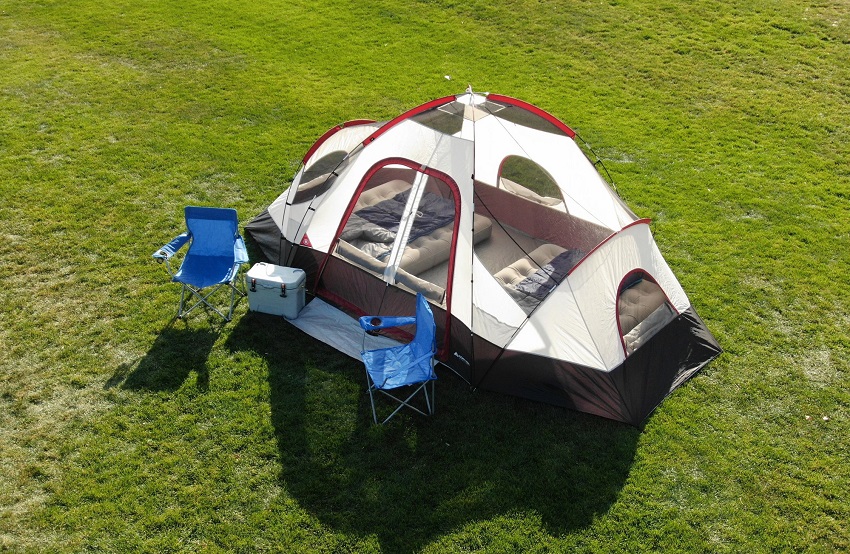 Two blue camping chairs stand near the Ozark Trail 8-Person Dome tent without a rainfly