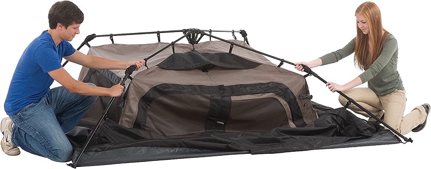 A man and a woman set up the Coleman 4-Person Cabin Camping Tent With Instant Setup