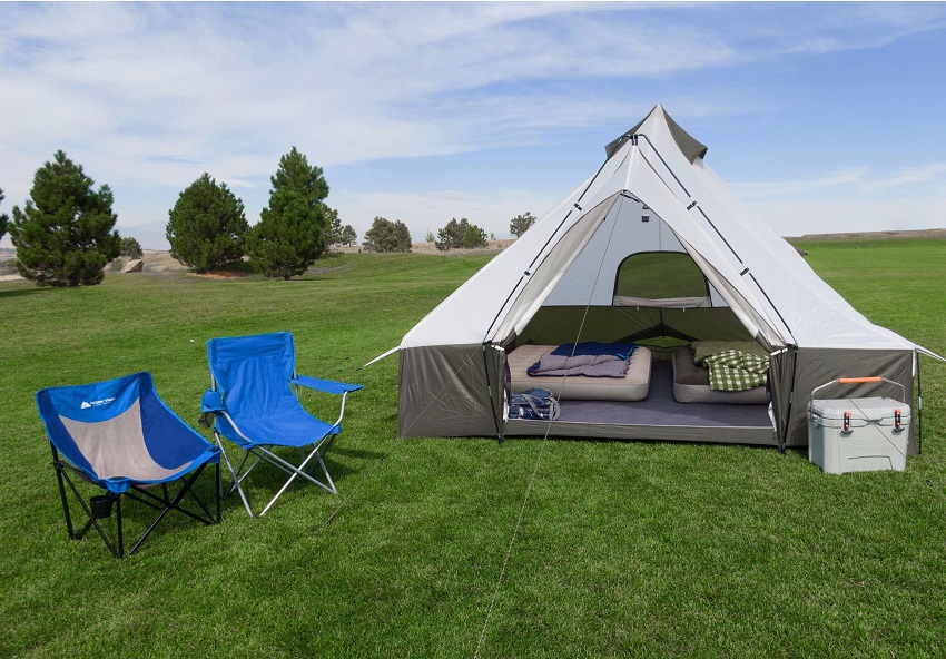 Two blue camping chairs stand near the white/green Ozark Trail Hazel Creek 8-Person Lodge tent