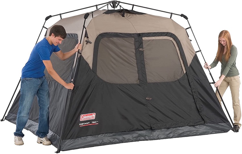 A man and a woman set up the Coleman 4-Person Cabin Camping Tent With Instant Setup