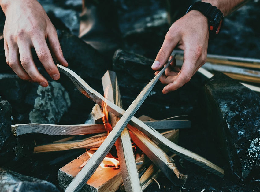 Human hands build a campfire