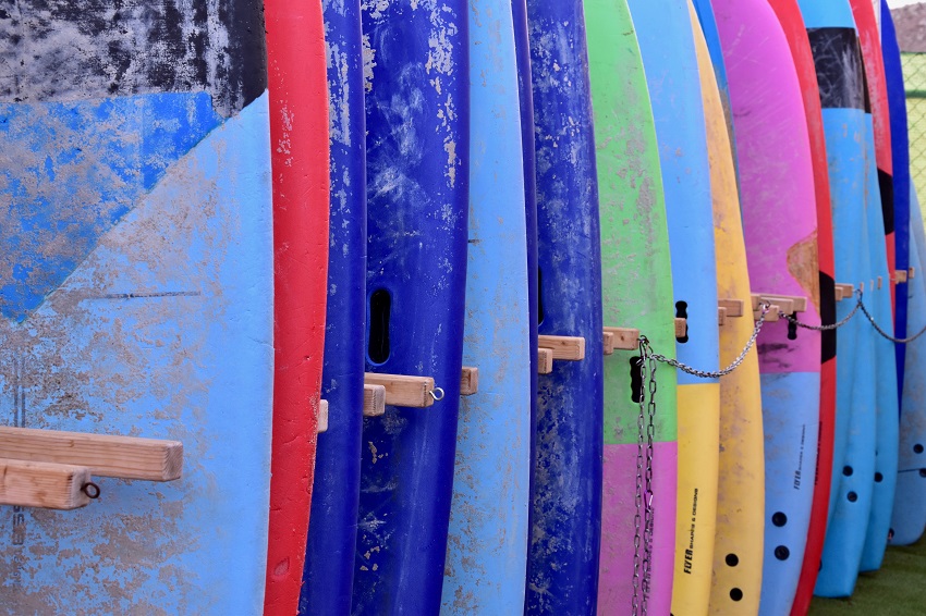 SUP boards of different colors and sizes are stored on racks