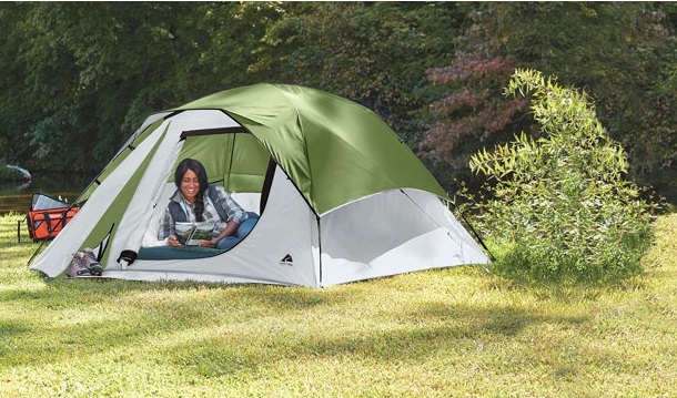 A woman reads a magazine inside the Ozark Trail 4-Person Clip & Camp Dome tent