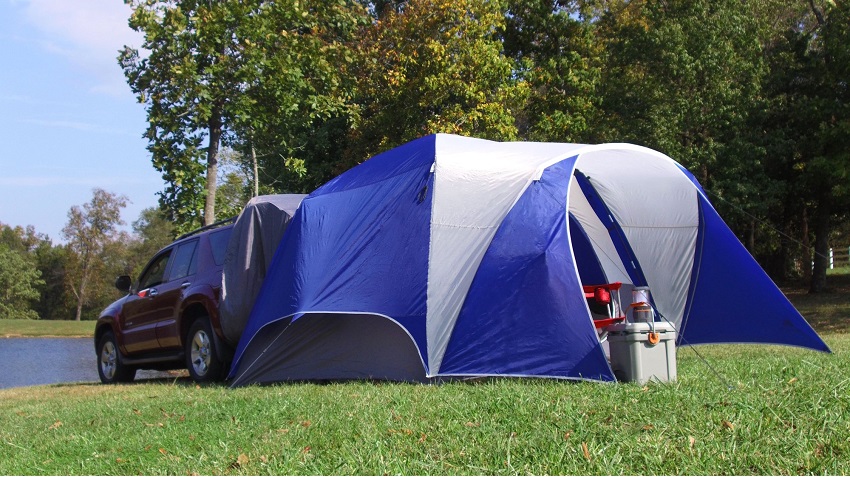 White and blue Ozark Trail 5-Person Dome Tent, attached to a red SUV