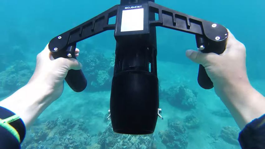 Scubajet PRO Underwater Scooter is held by human hands under water