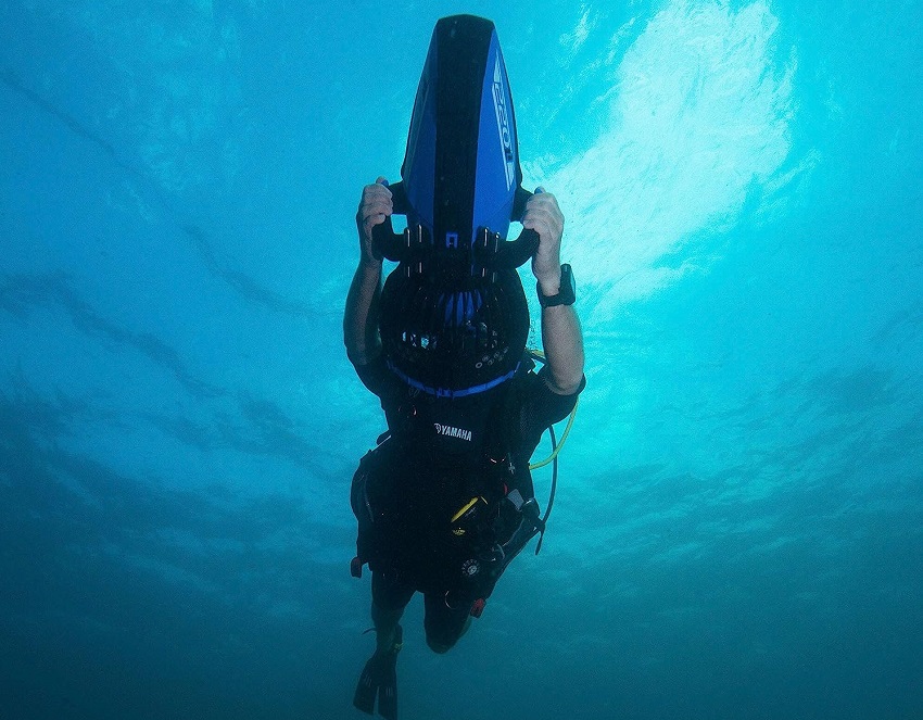 A man rides an underwater scooter