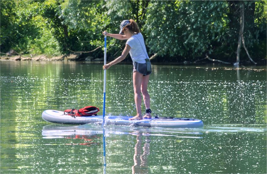 A woman paddles a SUP on a river