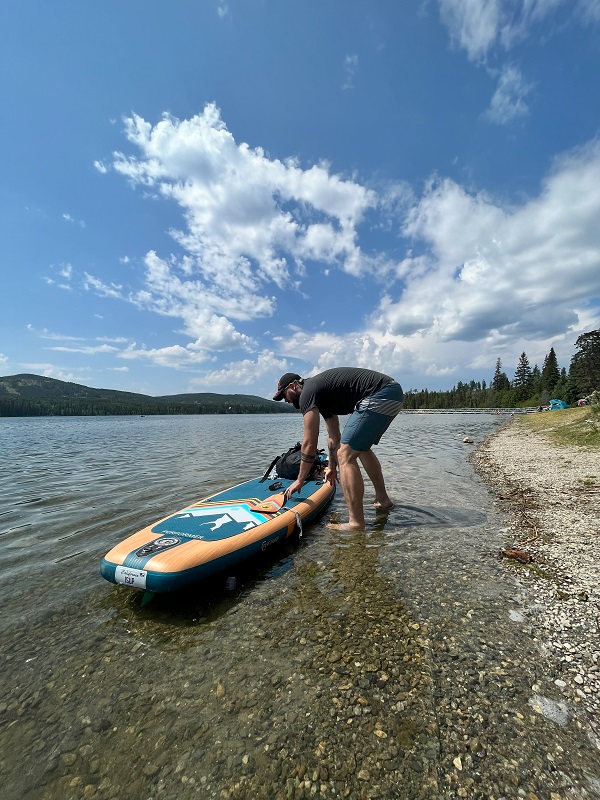 Author is putting the loaded BodyGlove Performer 11 Inflatable SUP on water