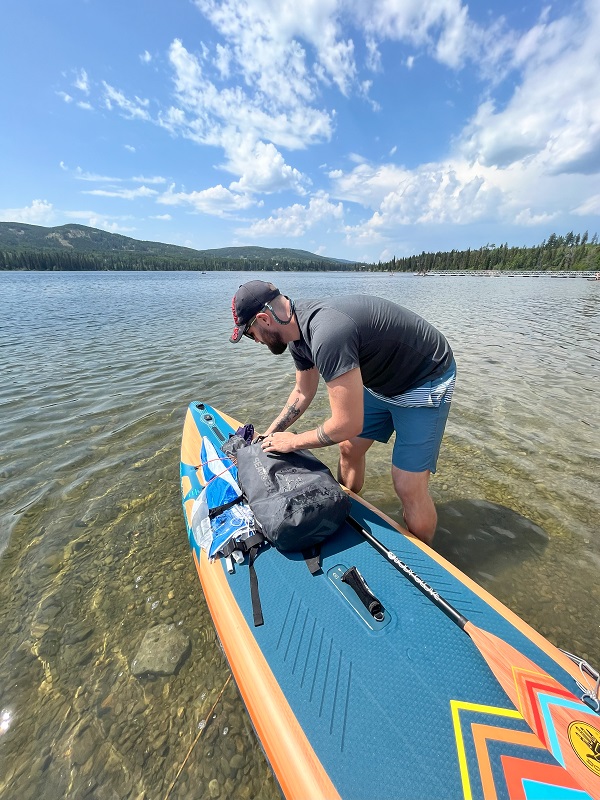 Author loads his gear on the BodyGlove Performer 11 Inflatable SUP on water